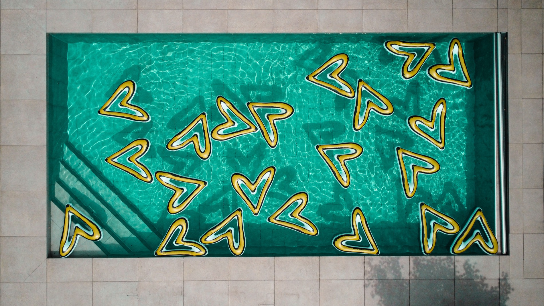 Aerial view of a pool with heart-shaped light installation